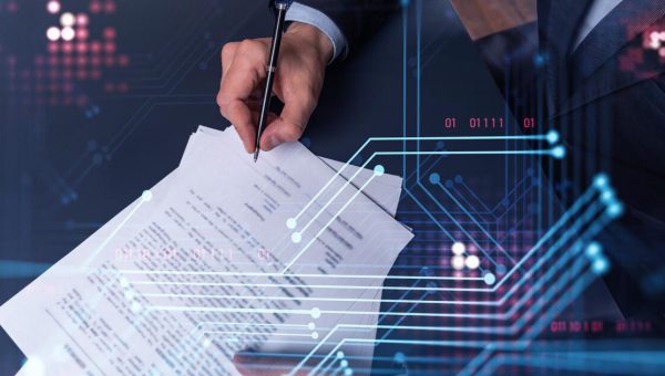 Hand signing a contract with a digital circuit overlay representing a data processing agreement